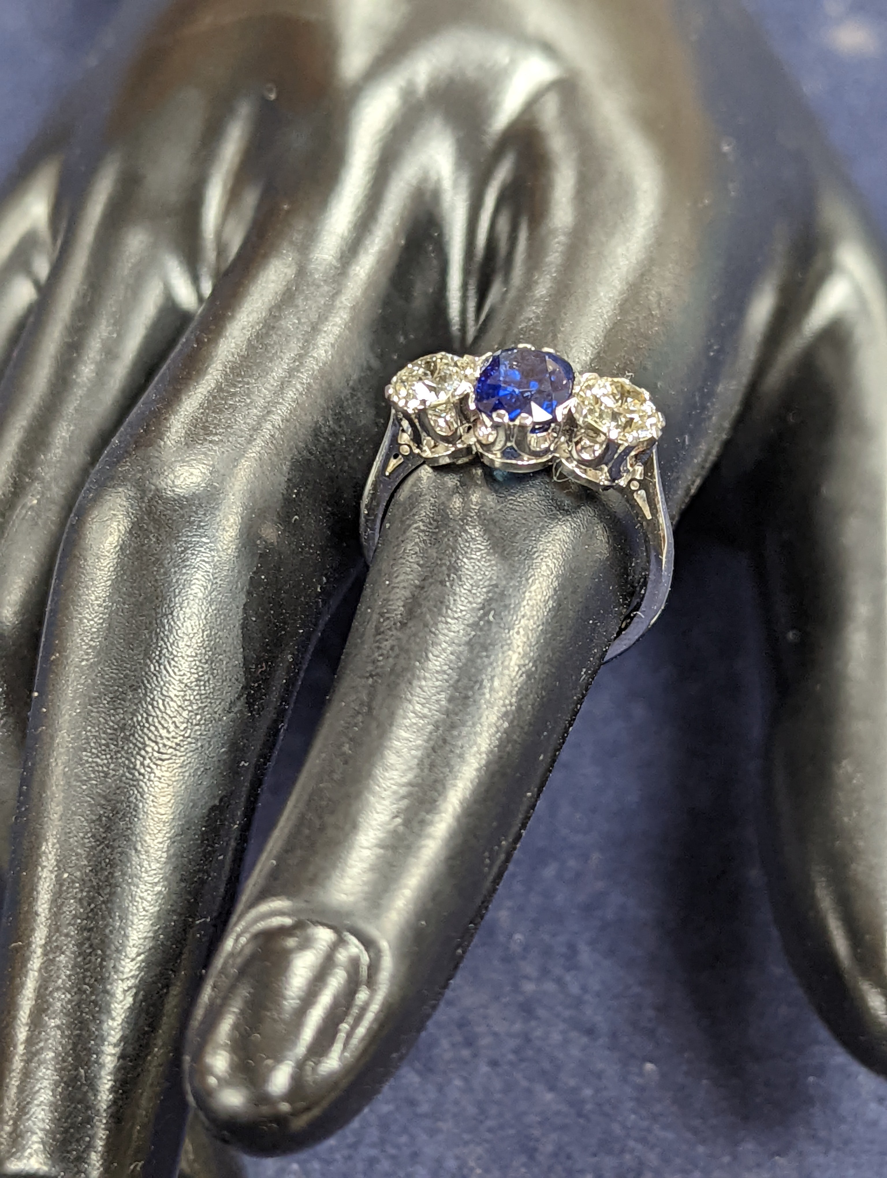 A modern 18ct white gold, single stone sapphire and two stone diamond set ring, size L, gross weight 4.2 grams